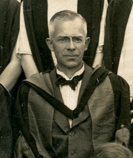 Black and white photograph of P W Bryan wearing academic dress, from the class photograph of 1925 (ULA/FG5/1/3)